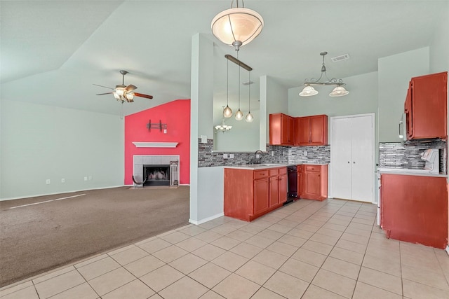 kitchen featuring hanging light fixtures, light carpet, ceiling fan, a tiled fireplace, and backsplash