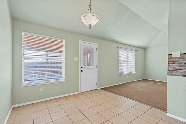 carpeted foyer entrance with vaulted ceiling