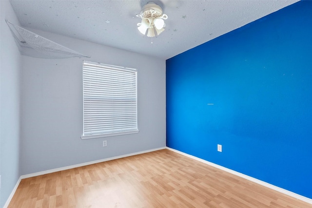 unfurnished room featuring ceiling fan, light hardwood / wood-style floors, and a textured ceiling