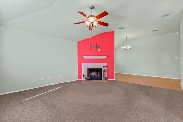 unfurnished living room featuring a tile fireplace, carpet flooring, ceiling fan with notable chandelier, and high vaulted ceiling