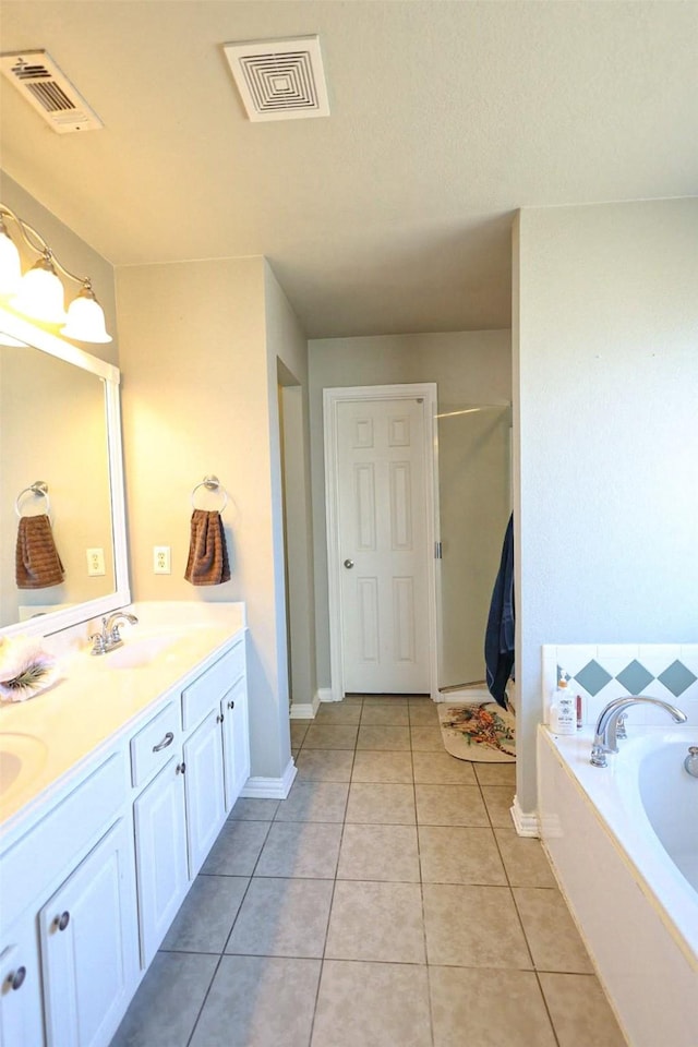 bathroom with tile patterned flooring, a bath, and vanity