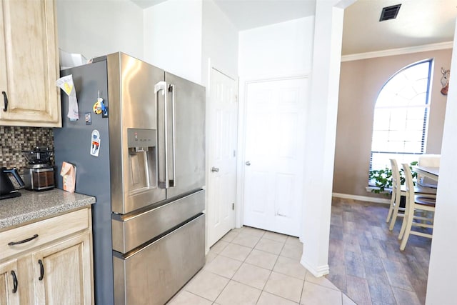 kitchen featuring tasteful backsplash, visible vents, light brown cabinetry, ornamental molding, and stainless steel fridge