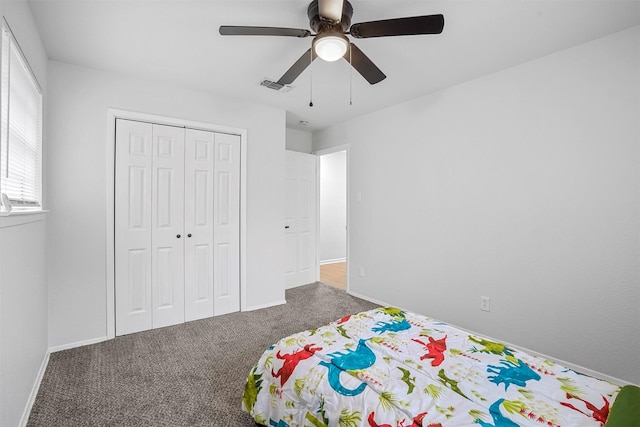 unfurnished bedroom with dark colored carpet, ceiling fan, and a closet