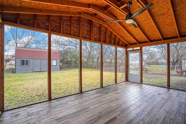 unfurnished sunroom with lofted ceiling, a healthy amount of sunlight, and ceiling fan