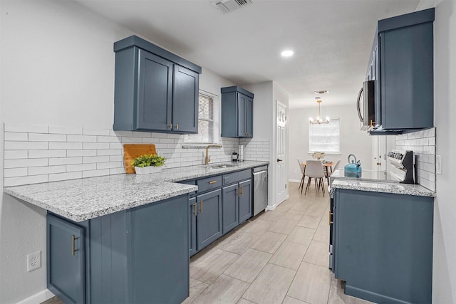 kitchen with stainless steel appliances, sink, blue cabinets, and decorative light fixtures