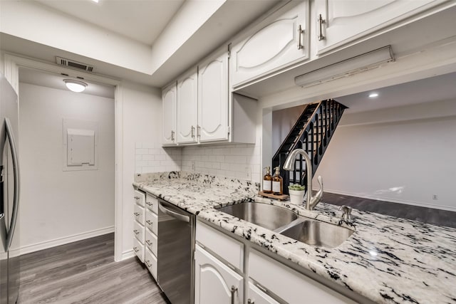 kitchen with sink, dishwasher, white cabinetry, backsplash, and hardwood / wood-style floors