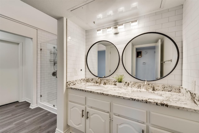 bathroom with vanity, hardwood / wood-style floors, and a tile shower