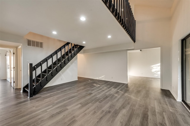 unfurnished living room featuring hardwood / wood-style flooring and a high ceiling