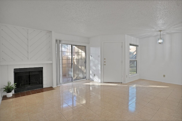 unfurnished living room with light tile patterned floors, a notable chandelier, and a textured ceiling