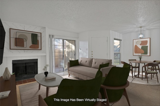 living room featuring a fireplace, tile patterned floors, and a textured ceiling