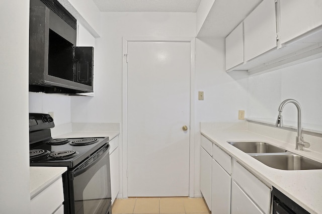 kitchen featuring sink, light tile patterned floors, dishwasher, electric range, and white cabinets