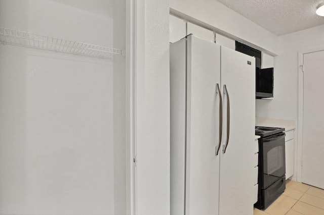 kitchen featuring white cabinetry, black range with electric stovetop, a textured ceiling, and white refrigerator