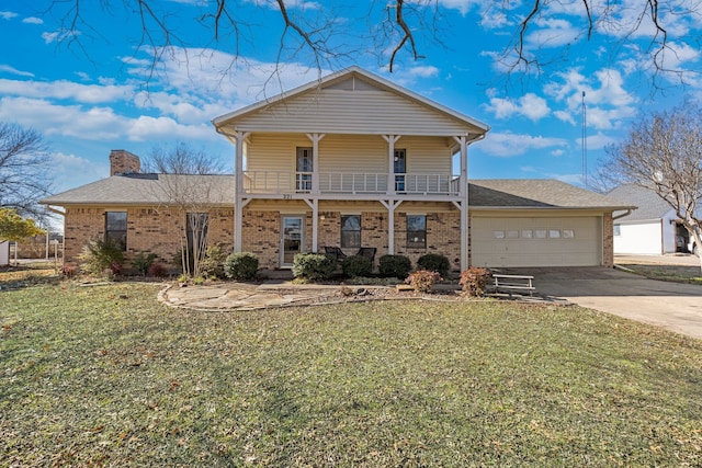 view of front facade with a balcony, a garage, and a front yard