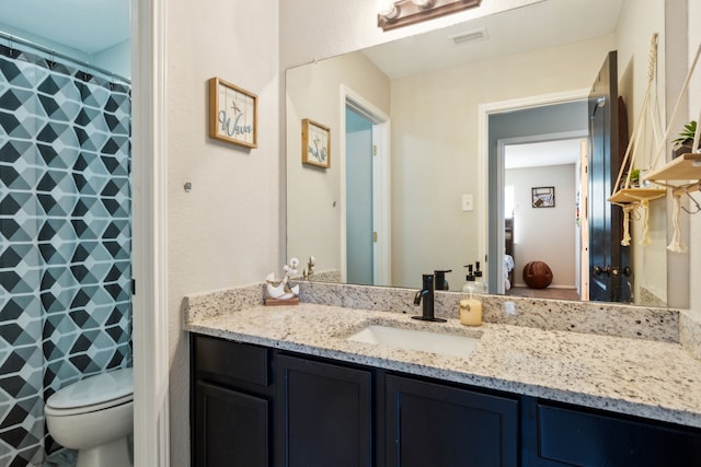 bathroom featuring vanity, curtained shower, and toilet