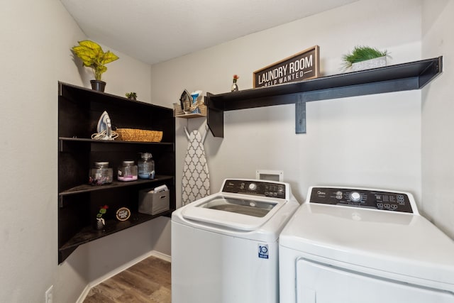 clothes washing area with hardwood / wood-style floors and washer and dryer