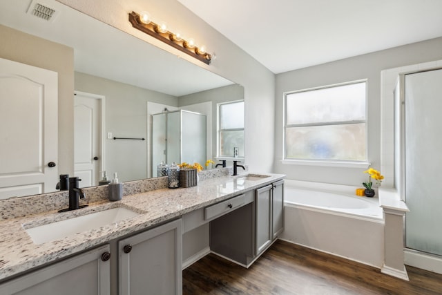 bathroom featuring hardwood / wood-style flooring, vanity, and separate shower and tub