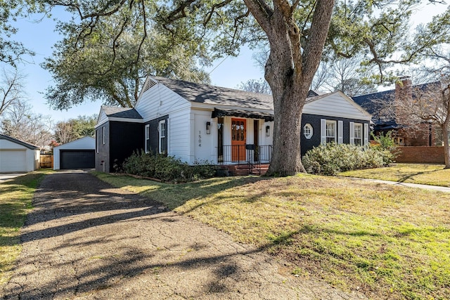 view of front facade featuring an outbuilding, a garage, and a front yard