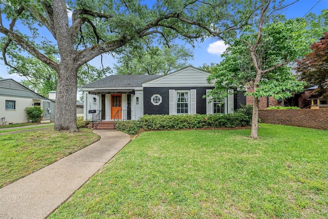 single story home featuring brick siding and a front yard