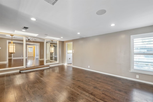 unfurnished room featuring dark hardwood / wood-style flooring and a skylight