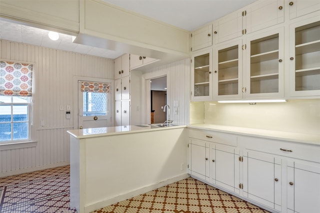 kitchen with white cabinetry, sink, and kitchen peninsula