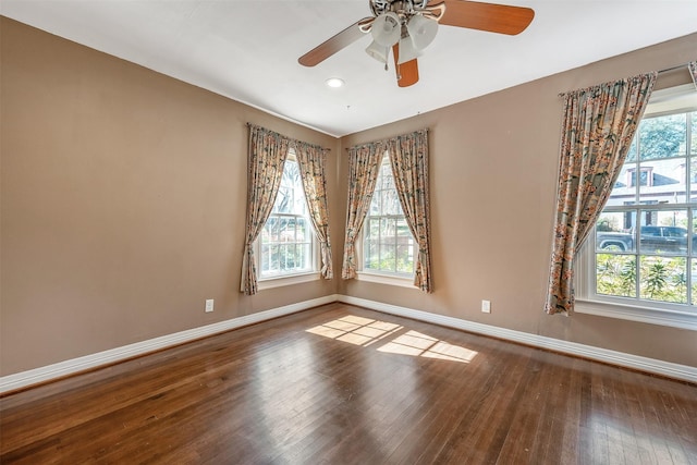 spare room with wood-type flooring, a healthy amount of sunlight, and ceiling fan