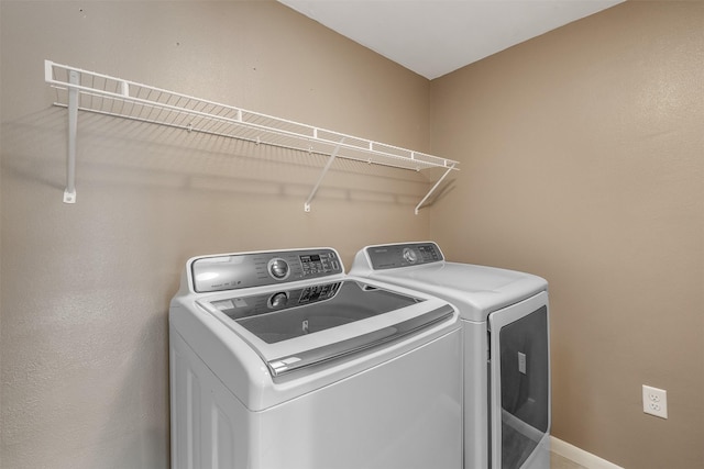 clothes washing area with washing machine and dryer