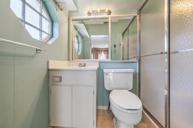 full bath featuring toilet, a shower with shower door, and vanity