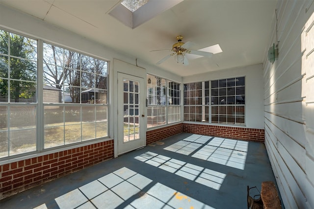 unfurnished sunroom with a ceiling fan and a skylight