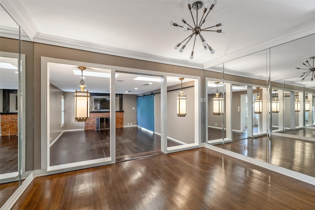 interior space with crown molding, a brick fireplace, dark hardwood / wood-style floors, and a barn door