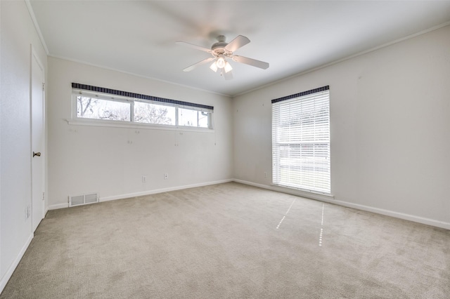 carpeted spare room with crown molding and ceiling fan