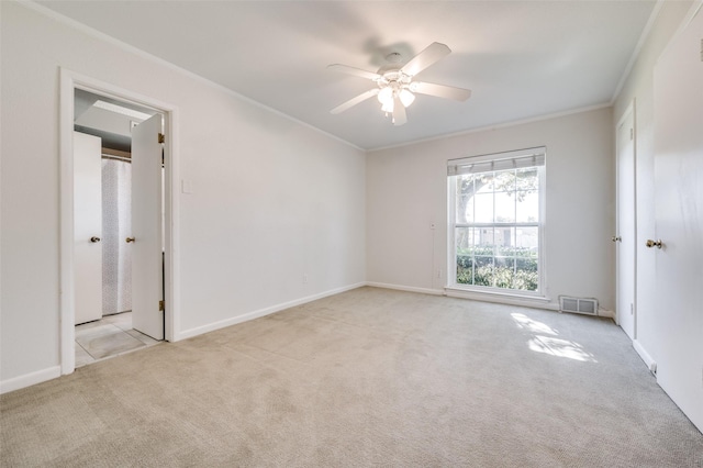 unfurnished room featuring crown molding, light colored carpet, and ceiling fan