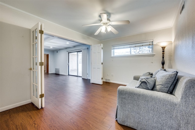 living room with dark hardwood / wood-style flooring, ornamental molding, and ceiling fan