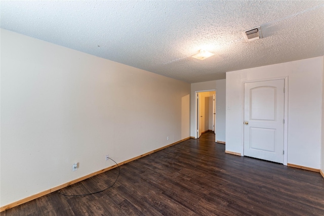 empty room featuring a textured ceiling and dark hardwood / wood-style flooring