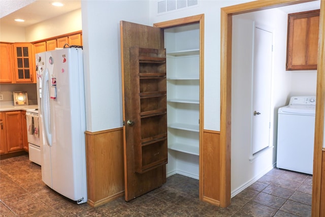 kitchen with washer / dryer and white appliances