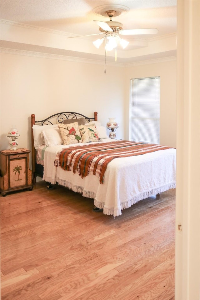 bedroom with hardwood / wood-style flooring, ceiling fan, and ornamental molding