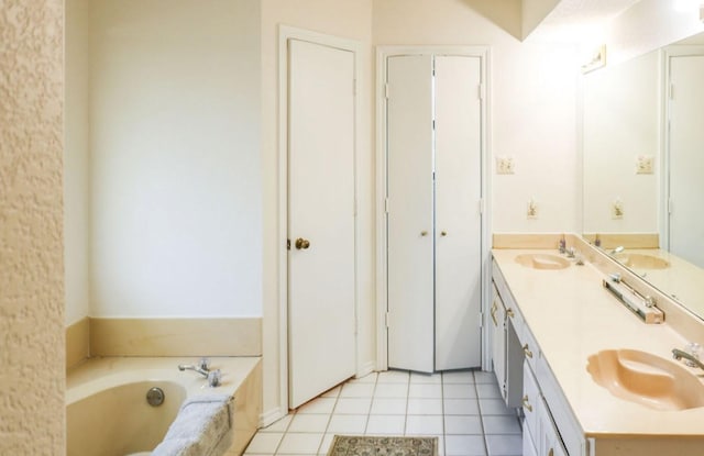 bathroom featuring a tub to relax in, vanity, and tile patterned flooring