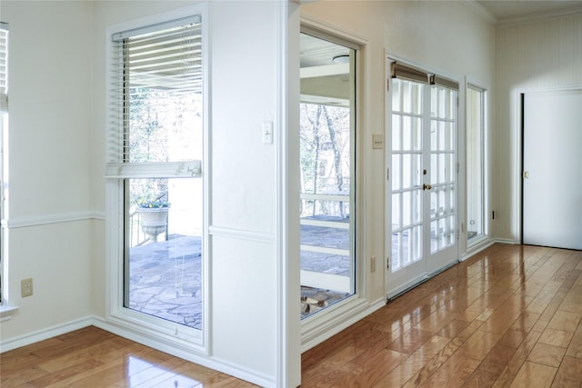 entryway with ornamental molding and hardwood / wood-style floors