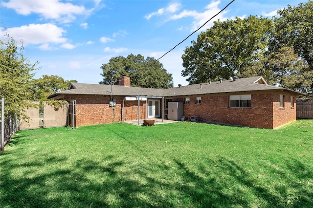 rear view of property featuring a yard and a patio area