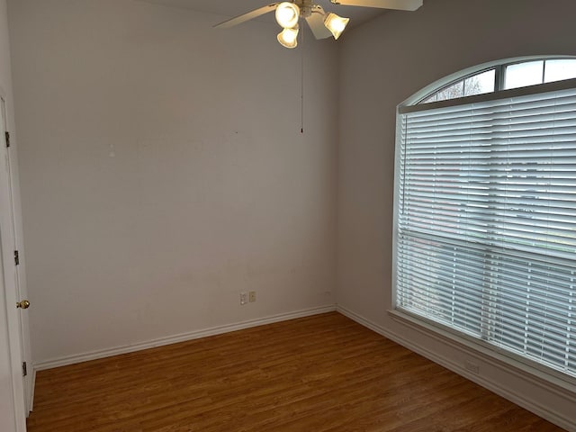 unfurnished room featuring wood finished floors, a ceiling fan, and baseboards