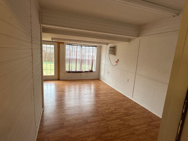 spare room with a wall mounted air conditioner and wood finished floors