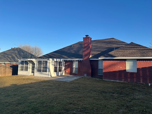 rear view of house featuring a chimney, fence, a patio, and brick siding