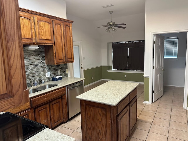 kitchen with light countertops, stainless steel dishwasher, light tile patterned flooring, and a sink