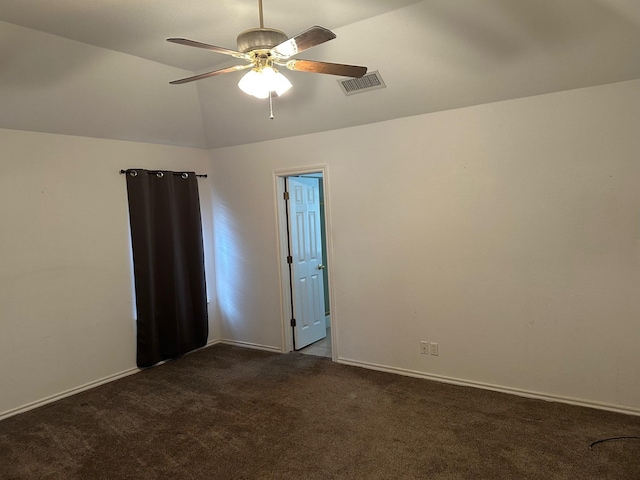 spare room featuring lofted ceiling, visible vents, dark carpet, ceiling fan, and baseboards