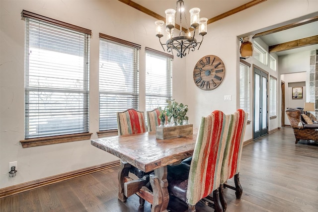 dining room featuring wood-type flooring, ornamental molding, french doors, and a chandelier