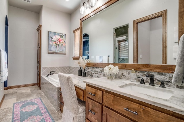 bathroom featuring vanity and tiled tub