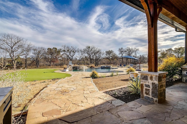 view of patio / terrace featuring pool water feature and a pool with hot tub