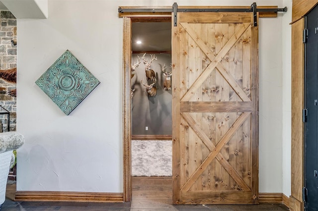 interior space with a barn door and hardwood / wood-style floors