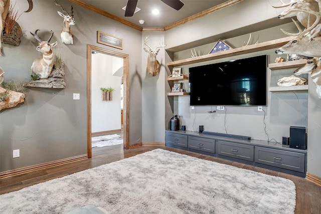 living room featuring hardwood / wood-style flooring, ornamental molding, and ceiling fan