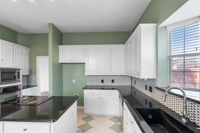 kitchen featuring white cabinetry, appliances with stainless steel finishes, sink, and tasteful backsplash