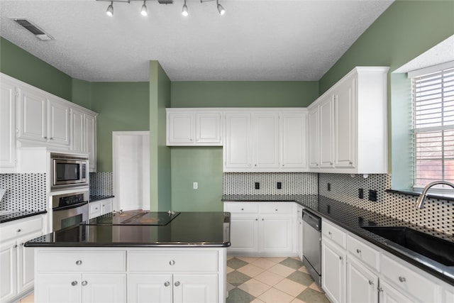 kitchen featuring white cabinetry, appliances with stainless steel finishes, sink, and decorative backsplash